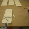 Finish coating the cabinet drawers by first rolling on a uniform coat of paint using the 3 inch roller.