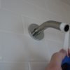Wrap several rotations of Teflon thread tape around both ends of the shower arm pipe.