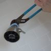 Use a folded rag to protect the shower head finish from the wrench.