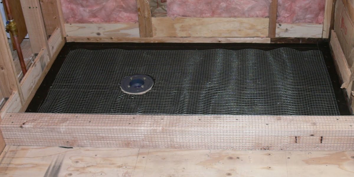 Shower pan construction - view of framing, tar paper, wire mesh and drain base.