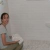 Elena shows off the freshly tiled shower walls and prepares to tile the shower pan.