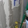 Cement board used to sheath wall over concealed toilet tank.