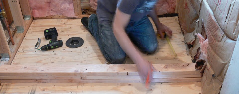 Frame shower pan curb by stacking 2x4 boards and attaching to the subfloor.