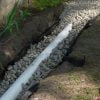 French drain assembly showing rock around drain pipe.