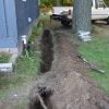 French drain trench dug next to problem area of cabin foundation.