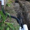 French drain install in yard trench near complete