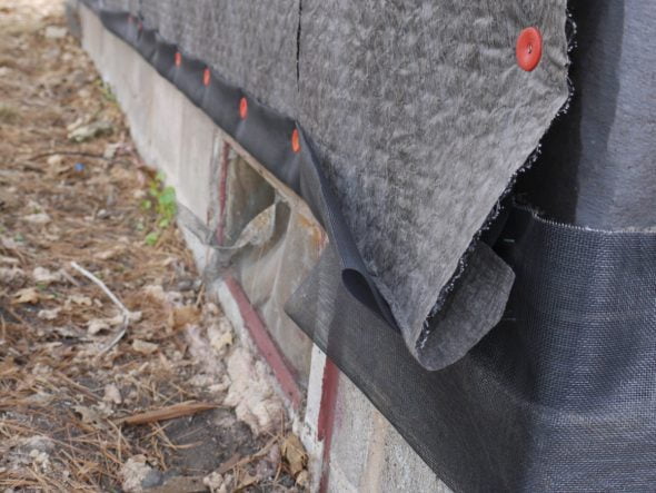 Rainscreen mat install showing addition of fiberglass screen over bottom of mat to serve as insect barrier.