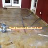 Using pre-drilled angle iron as screed guide for concrete pour to level floor.