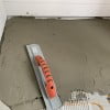 Magnesium float used to embed radiant in-floor heating mat in thinset mortar.