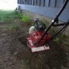 Using a mini rototiller to help dig trench for french drain.