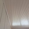 White painted quarter round finish used at edges of beadboard ceiling.