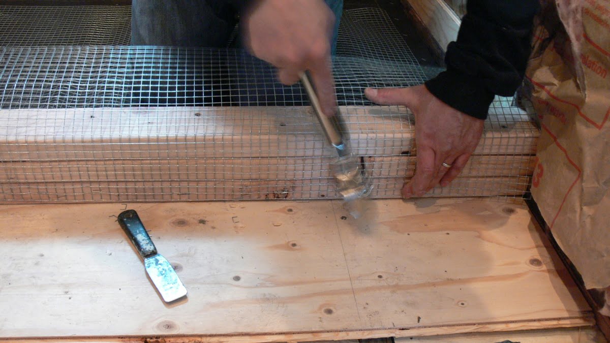 Secure wire mesh to 2x4 curb with galvanized staples.