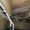 Sump pump discharge plumbing and vent plumbing in crawl space.
