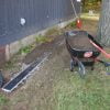 Yard surface drain install with top layer of black dirt to allow for grass planting.