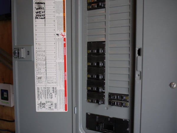 Electrical breaker panel in mechical room showing two 60 amp breakers for electric tankless water heater.