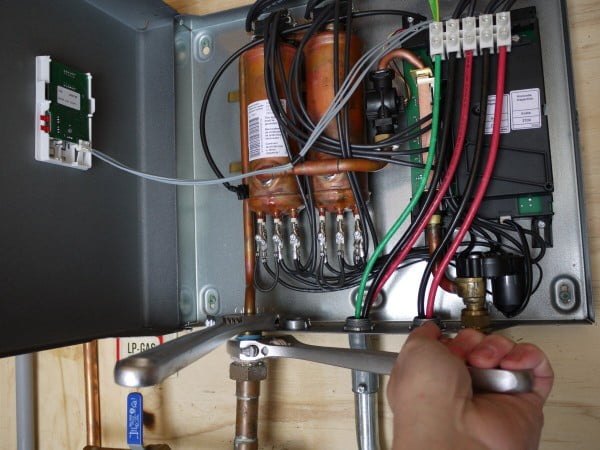 Closeup of plumbing connections at the base of the Stiebel Eltron tankless water heater.
